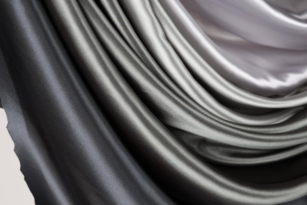 a close-up view of a fabric with a gradient of gray and black colors, creating a visually striking and textured appearance.
