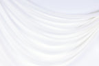 The image is a white fabric with a curved, flowing texture, creating a sense of softness and elegance.