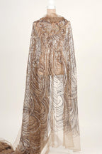 A mannequin wearing a long, flowing cape with a shimmering, sequined pattern.