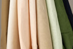 A close-up view of various fabric swatches in different colors, including peach, beige, and green.