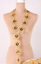 A mannequin wearing a gold necklace with numerous small, intricately designed flowers.