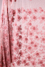 a close-up view of a delicate, pink floral fabric with a repeating pattern of pink flowers on a light pink background.