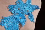 a close up of a blue flower on a dress