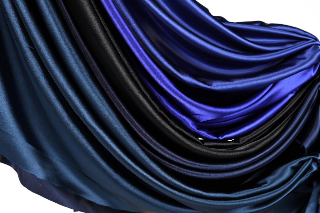 a close-up view of a fabric with a gradient of blue and black colors, creating a visually striking and textured appearance.