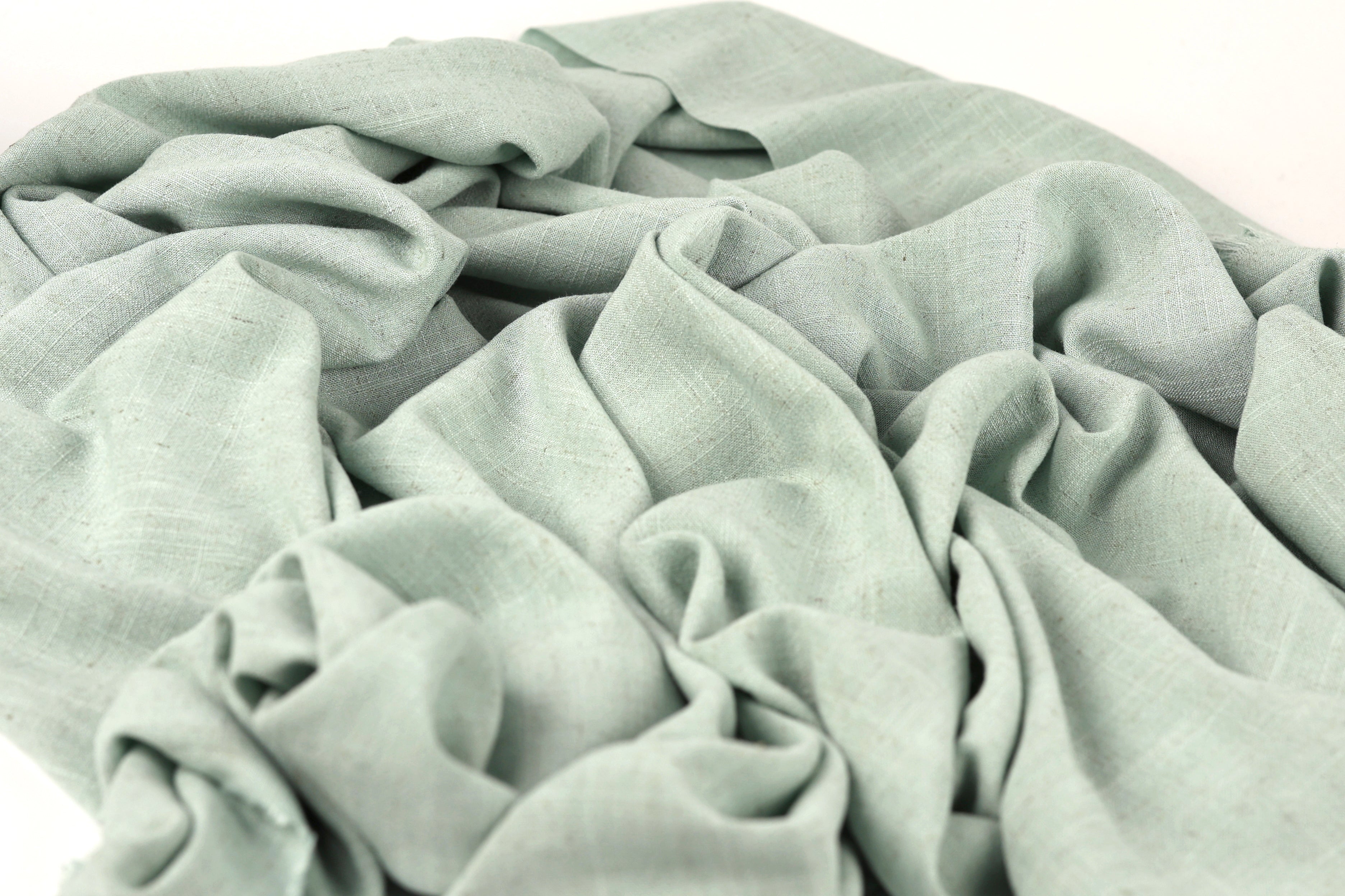 a close-up view of a crumpled, light green fabric, possibly a piece of clothing or textile.