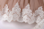 A close-up view of a delicate, lace-trimmed skirt or dress, with intricate patterns and designs.