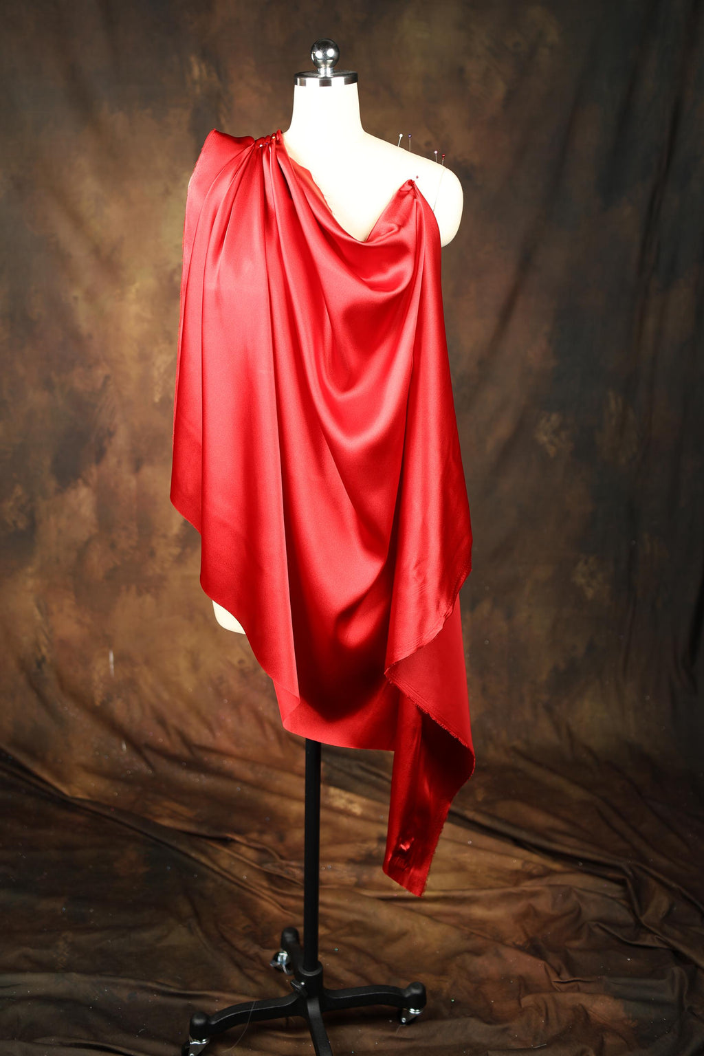 a mannequin wearing a red draped dress