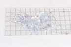 a clear ruler with a floral pattern on it, placed on a white surface.