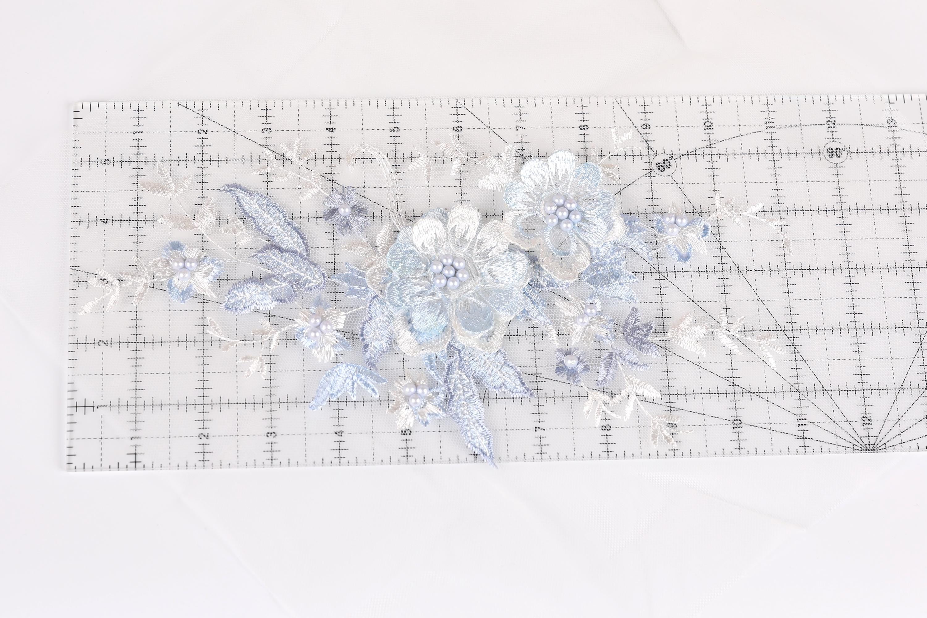 a clear ruler with a floral pattern on it, placed on a white surface.