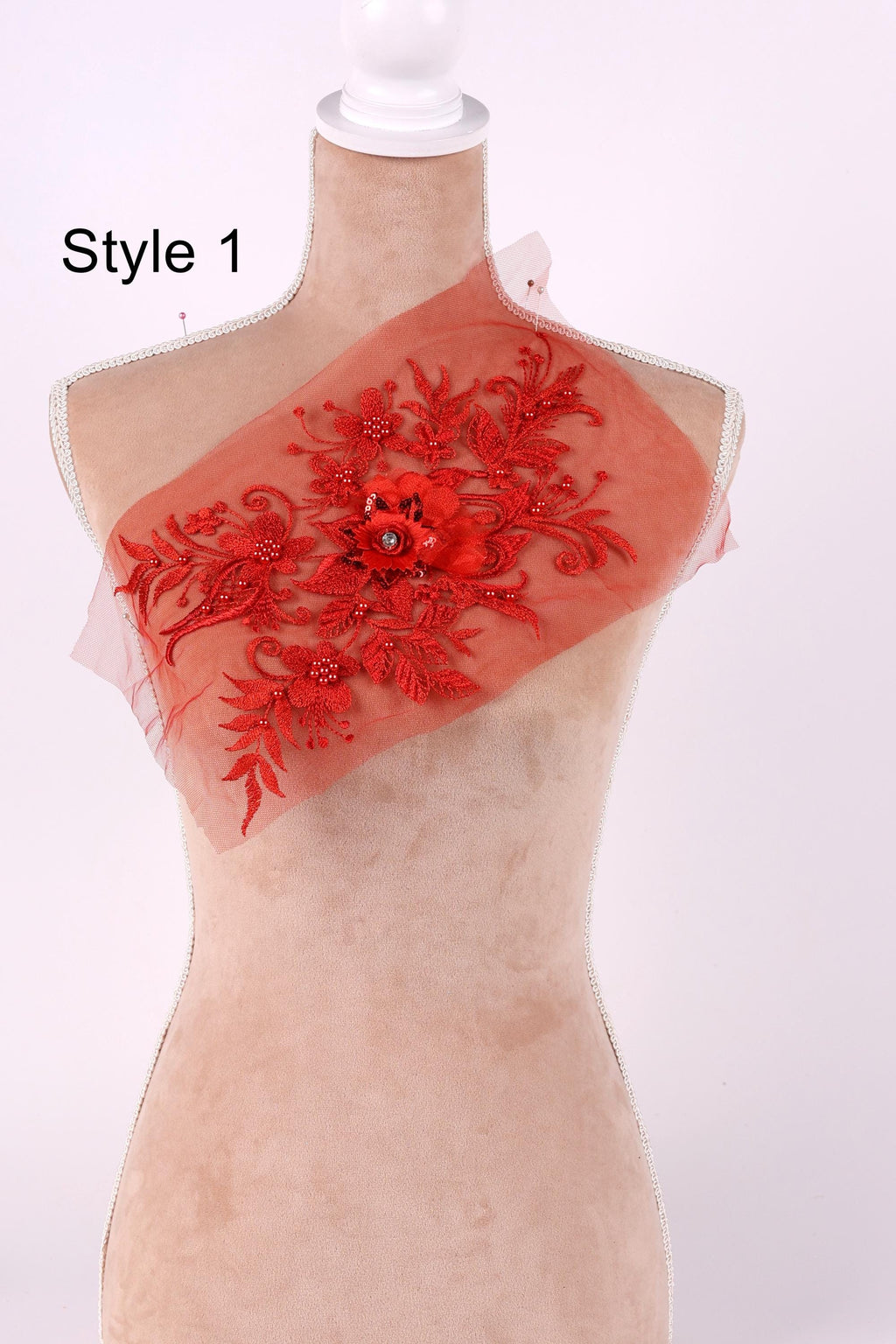 A mannequin with a red floral embroidered on its chest, displayed against a white background.