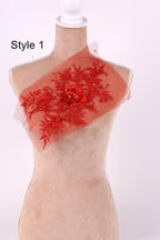 A mannequin with a red floral embroidered on its chest, displayed against a white background.