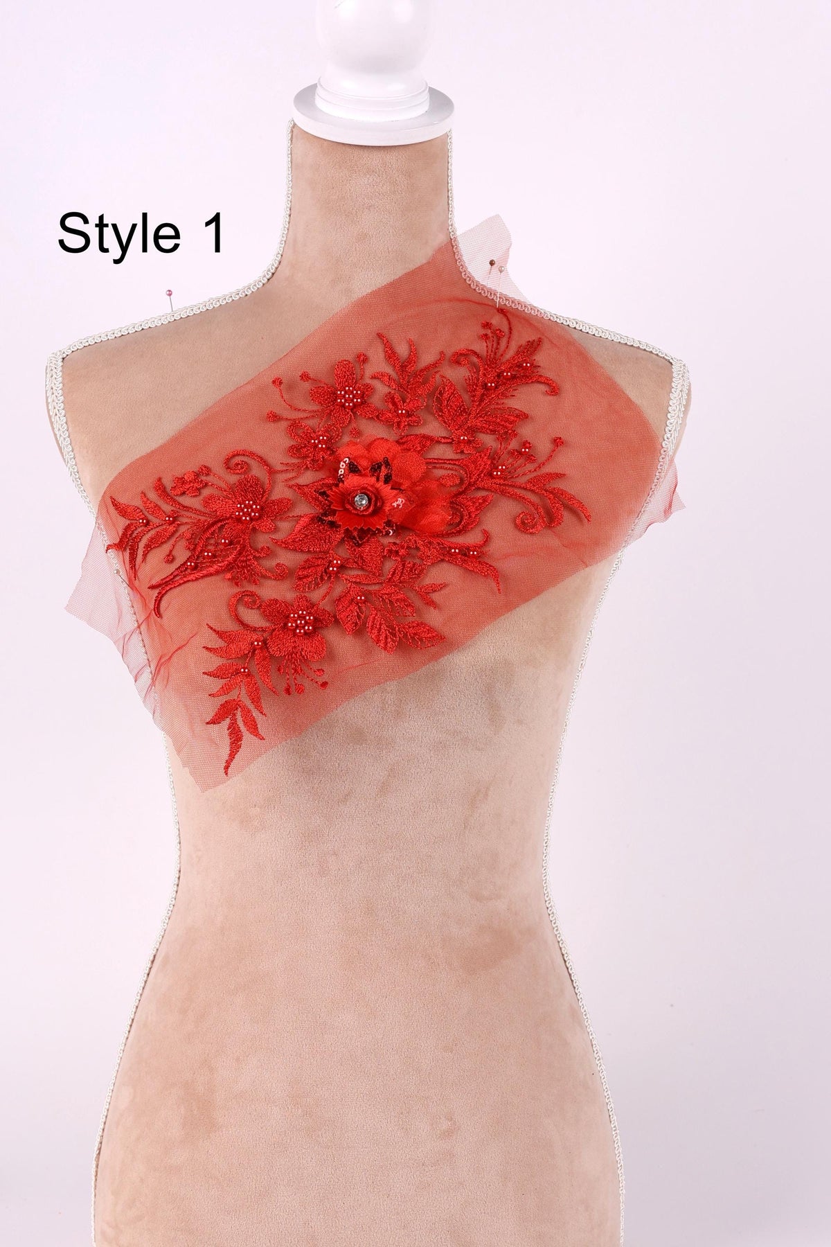 A mannequin with a red floral embroidered on its chest, displayed against a white background.