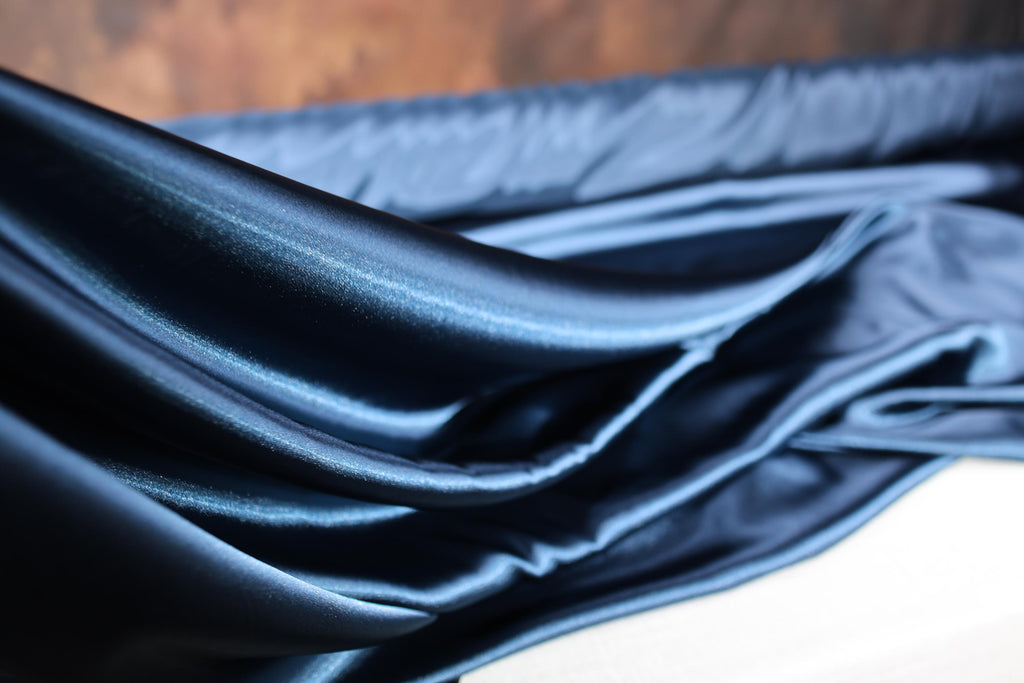 a close up of a blue cloth on a bed