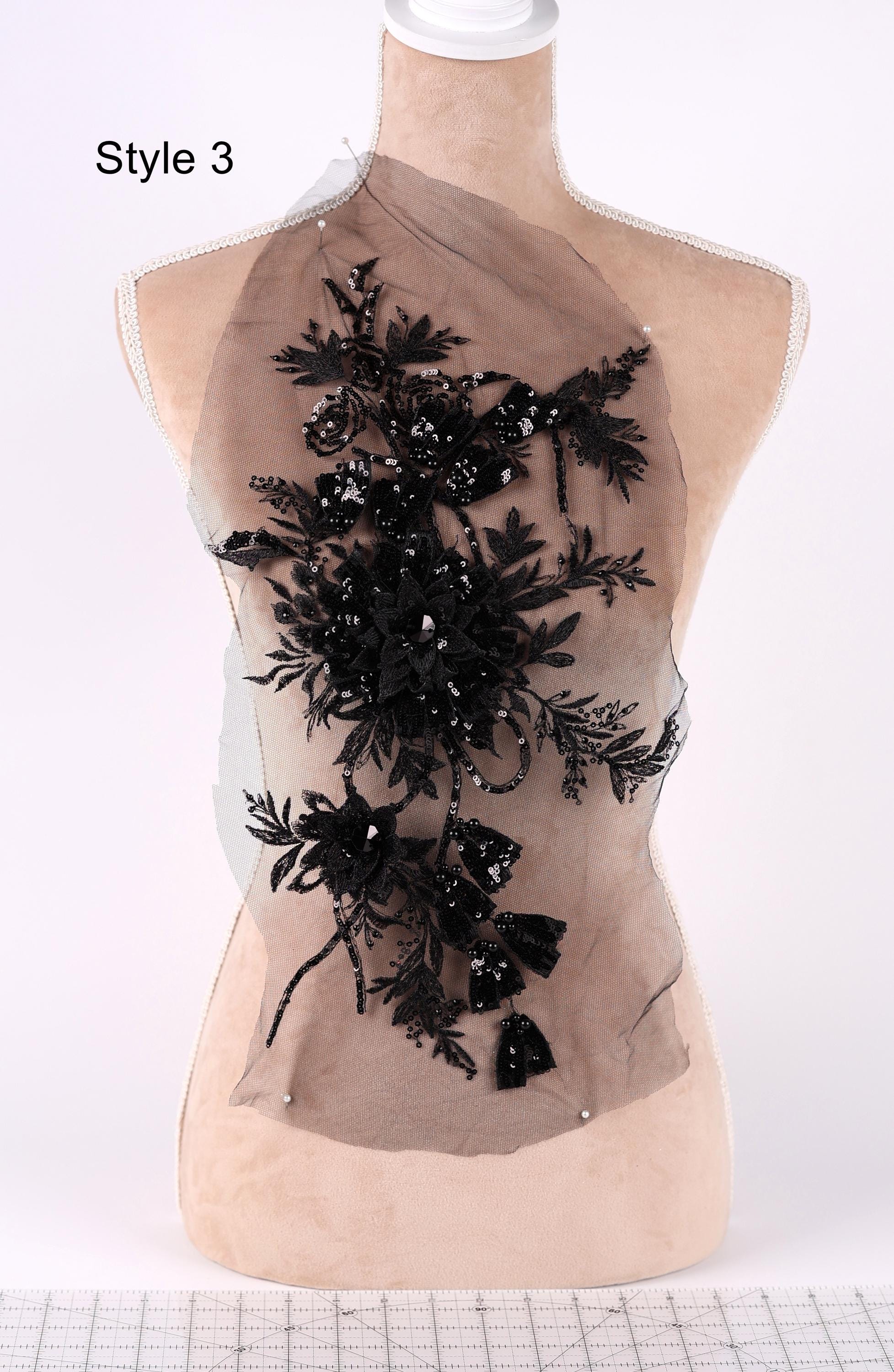 A mannequin with a decorative black floral pattern on its bust area, displayed on a mannequin stand.