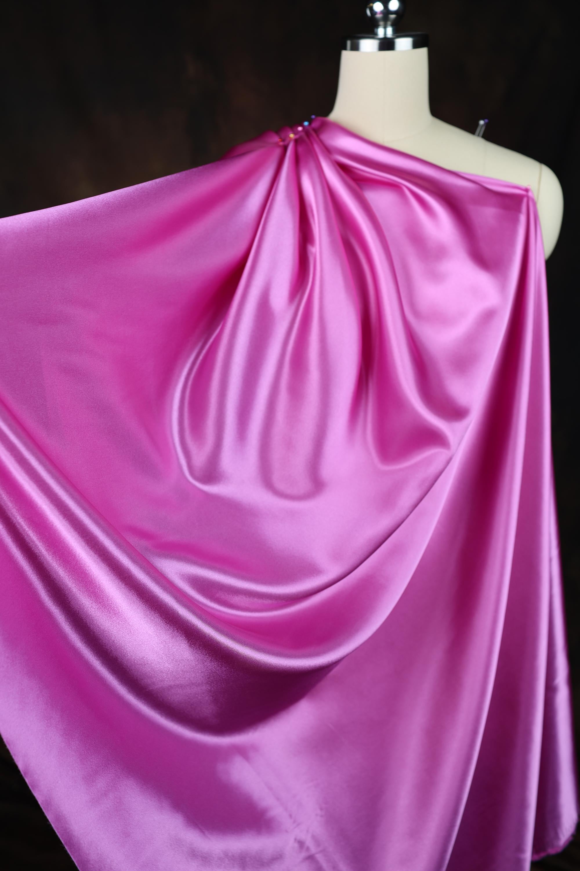 a mannequin wearing a pink draped dress