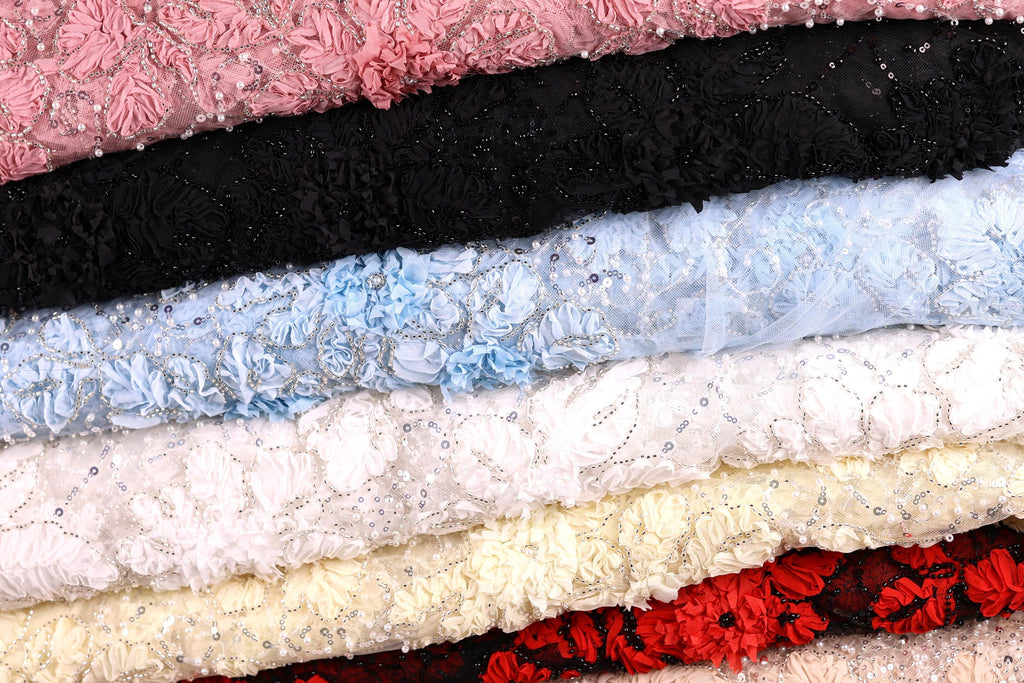 A close-up image of various colorful fabric swatches, including pink, black, blue, white, and red, arranged in a layered fashion.