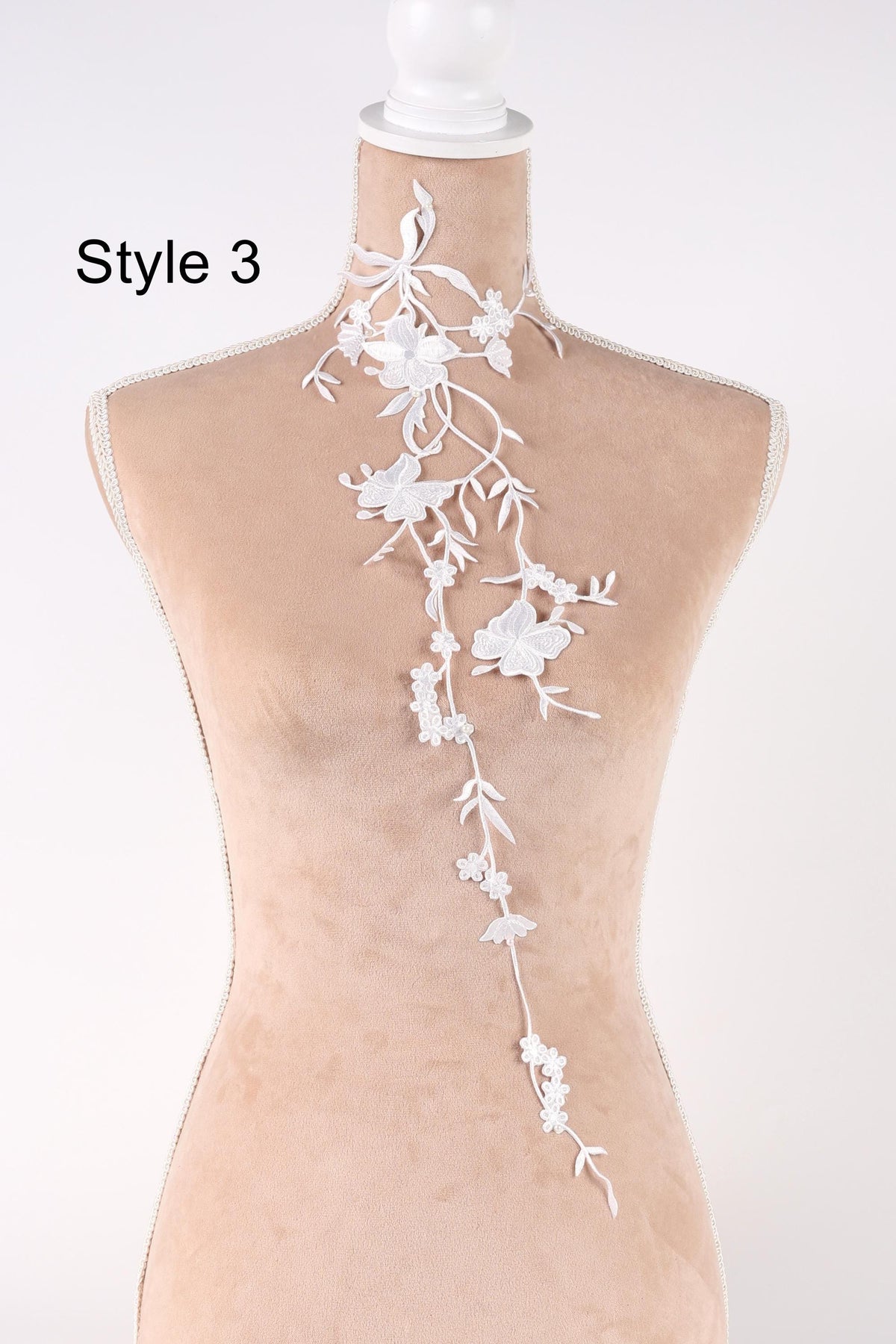 A mannequin with a delicate white floral embroidered on the back, showcasing a variety of styles.