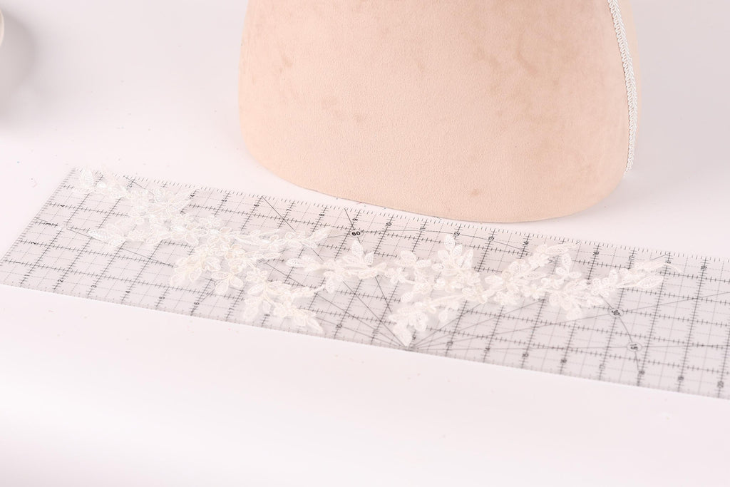 a piece of fabric with a lace pattern on it, placed on a ruler.