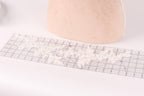 a piece of fabric with a lace pattern on it, placed on a ruler.