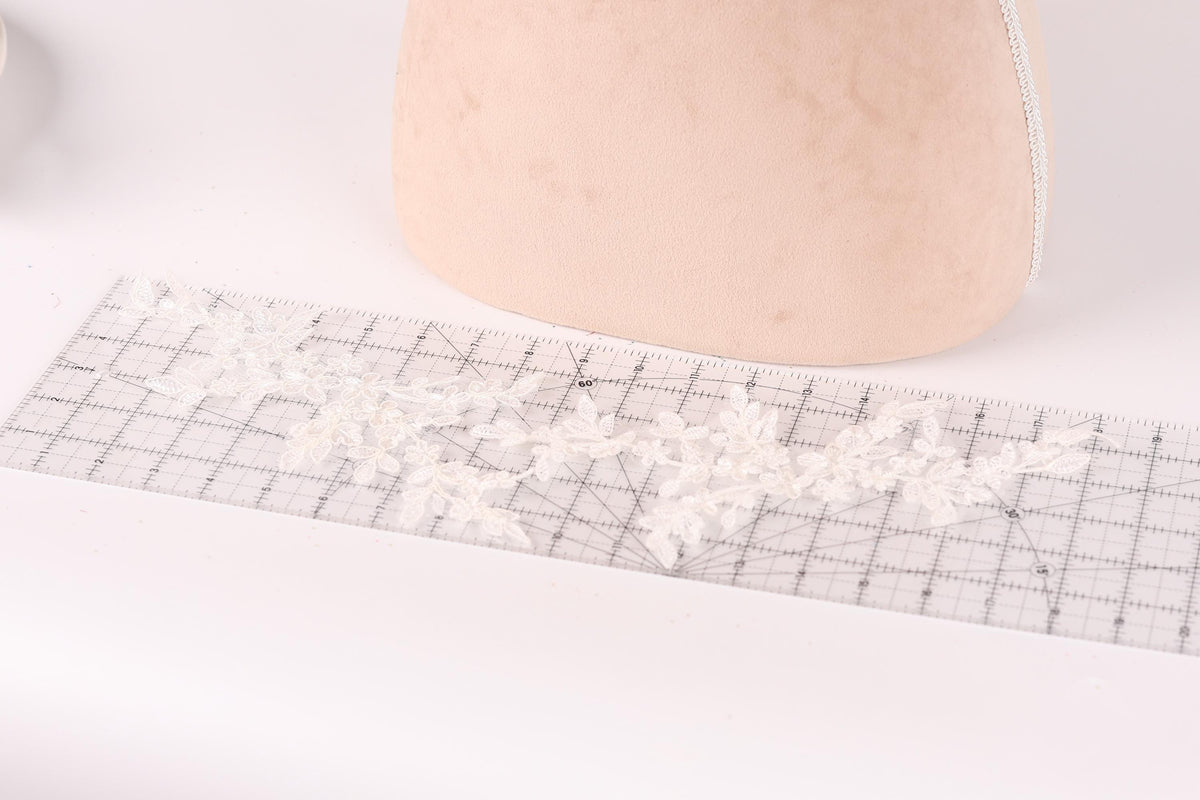 a piece of fabric with a lace pattern on it, placed on a ruler.