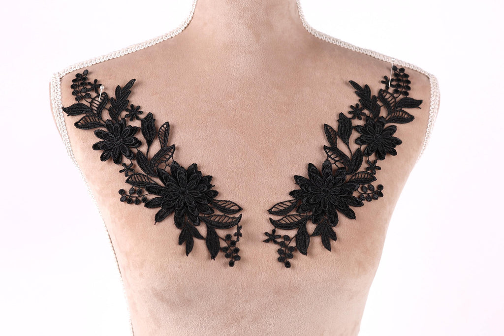 A mannequin torso with black floral embroidery on the bust area.