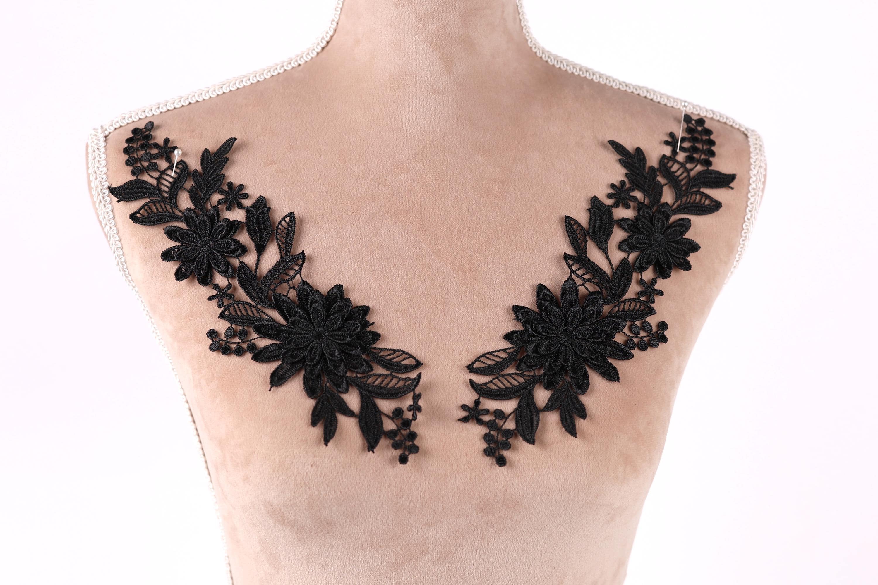 A mannequin torso with black floral embroidery on the bust area.