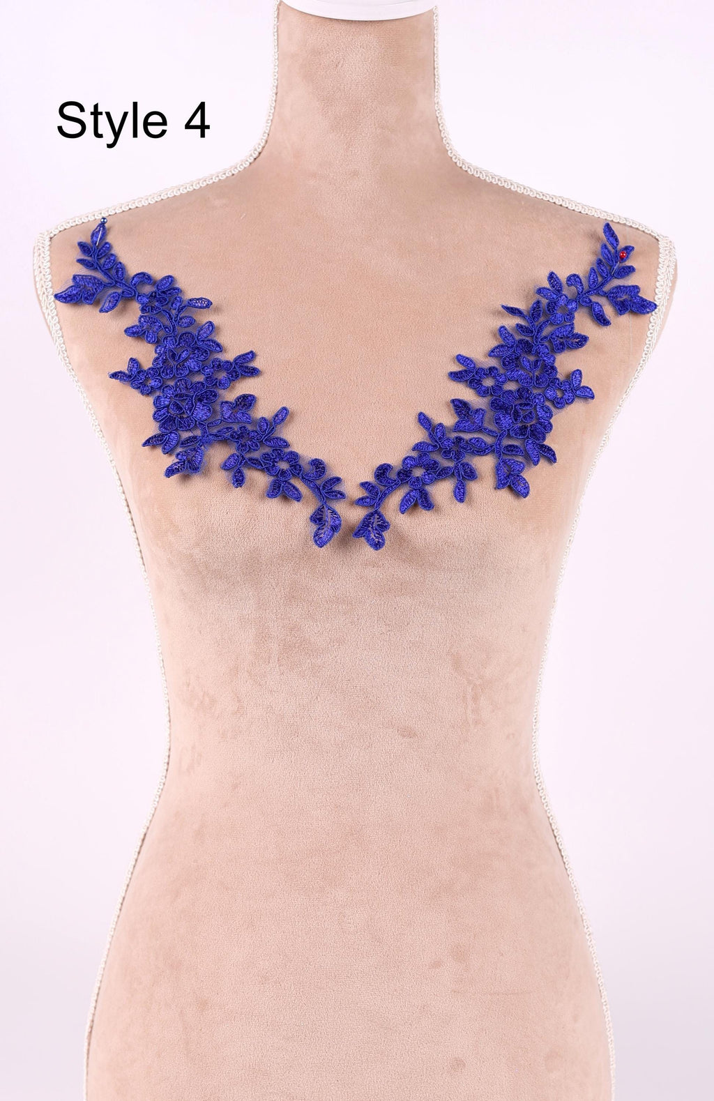 A mannequin with a beige body and a blue floral embroidered on the bust area.