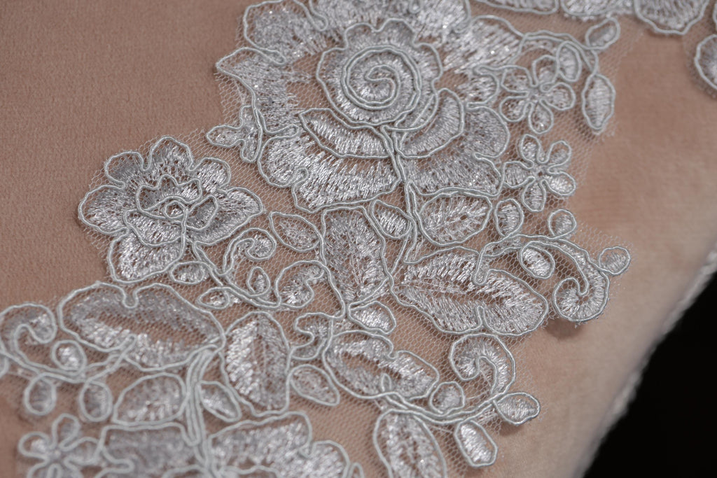a close-up view of a delicate, intricate lace pattern on a fabric surface.