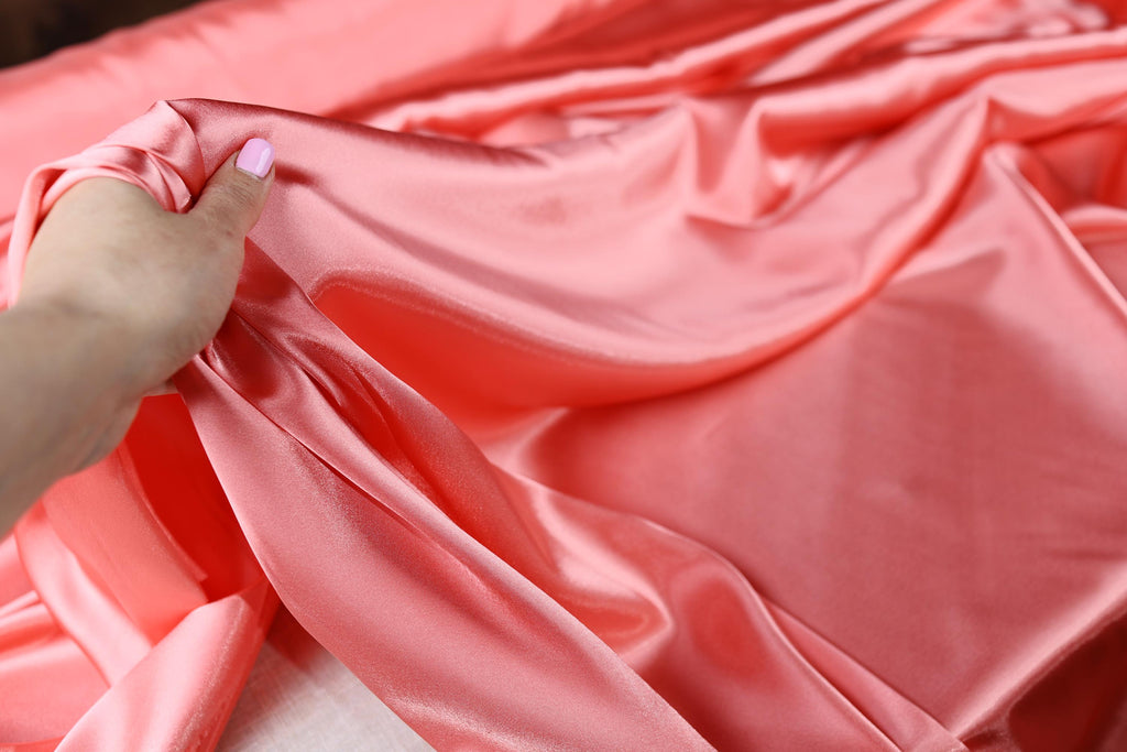 a person holding a piece of pink fabric