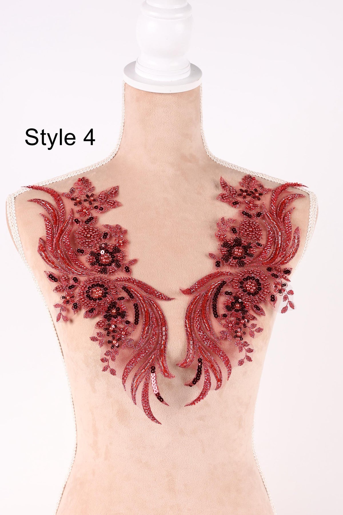A mannequin wearing a red and black floral embroidered neckline.