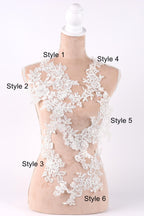 A mannequin with a white lace bodice and various lace patterns displayed on it, labeled with different styles.