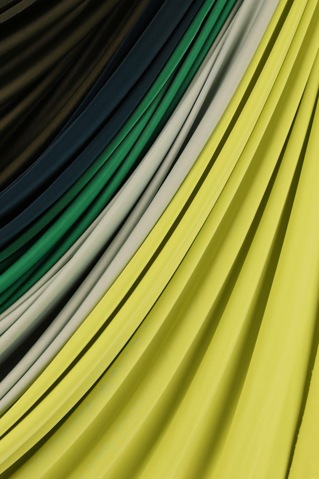 a close-up view of a vibrant yellow fabric with a diagonal pattern of green and white stripes.