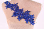 a close-up view of a mannequin torso with a decorative blue floral embroidery on the shoulder.
