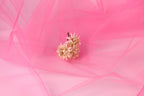 A single light pink flower is the focal point of the image, set against a soft pink background.