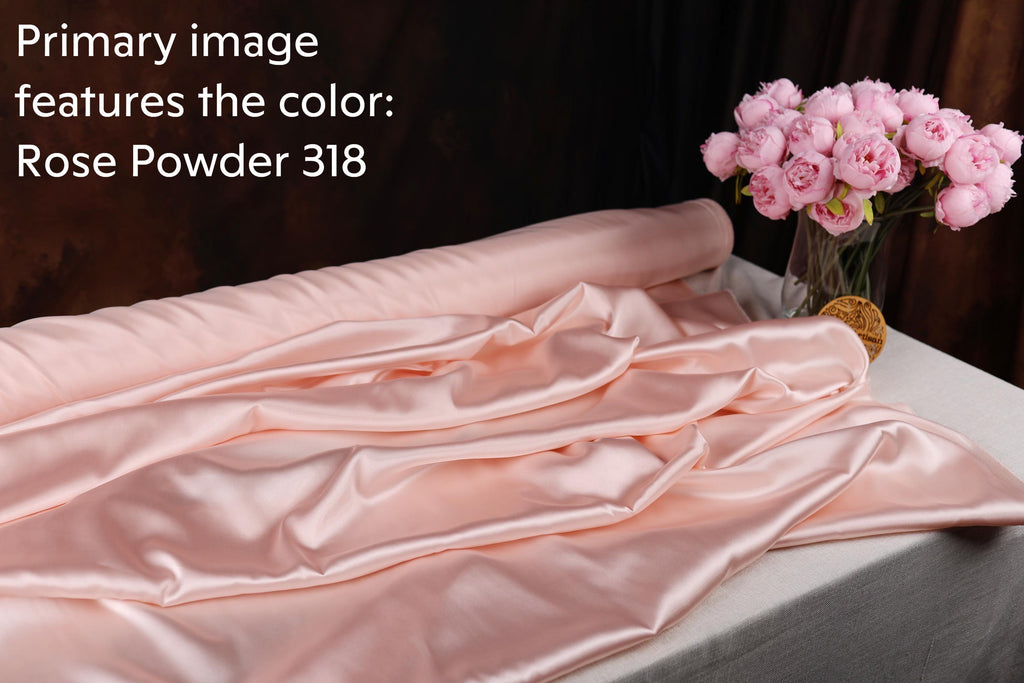 a pink satin fabric, a vase of pink roses, and a piece of rose powder.