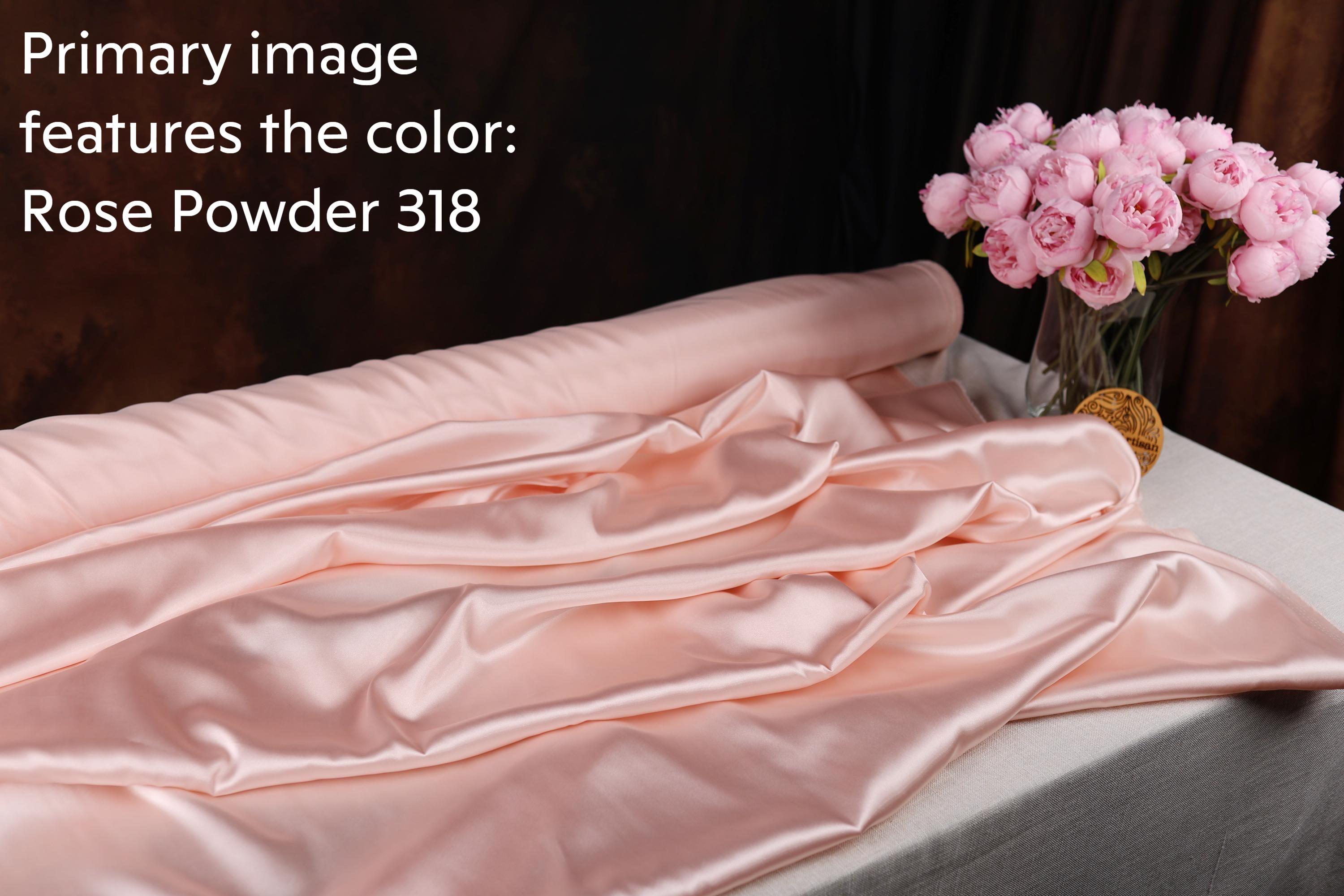 a pink satin fabric, a vase of pink roses, and a piece of rose powder.