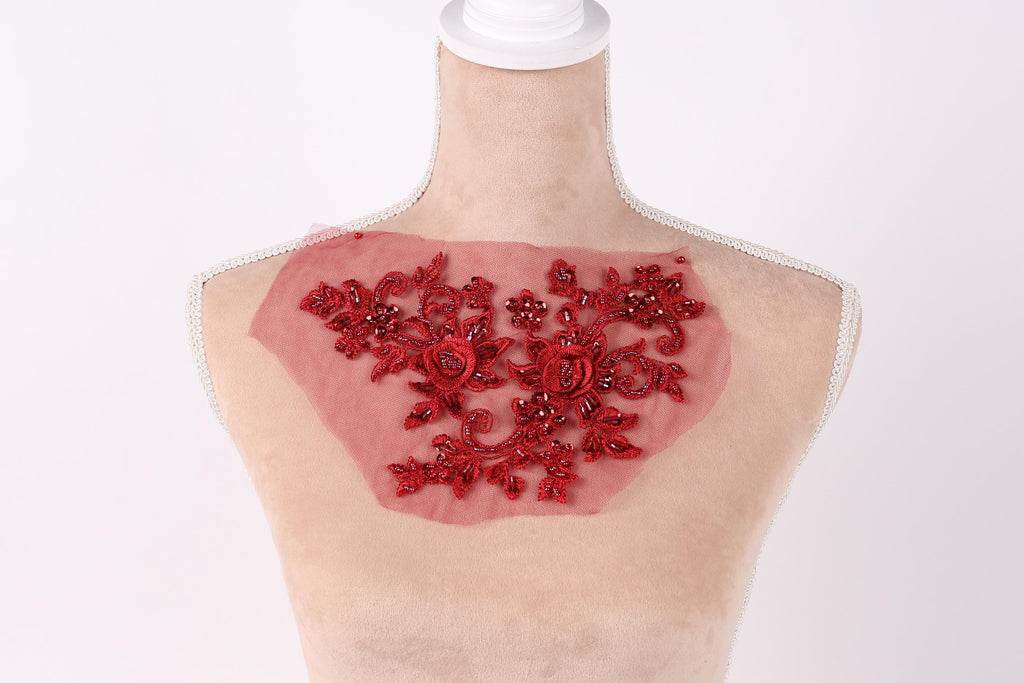 A mannequin with a red floral embroidered patch on its chest.