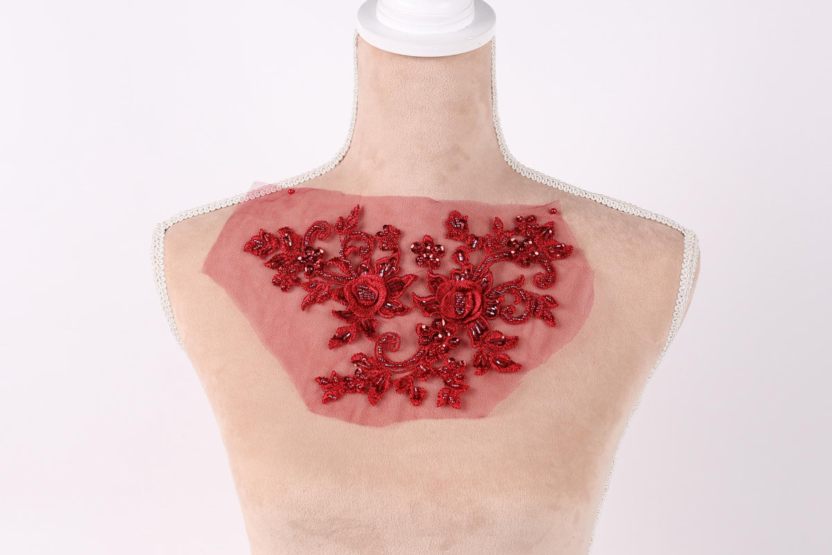 A mannequin with a red floral embroidered patch on its chest.
