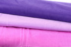 a close-up view of three fabric swatches in different colors: purple, pink, and white.