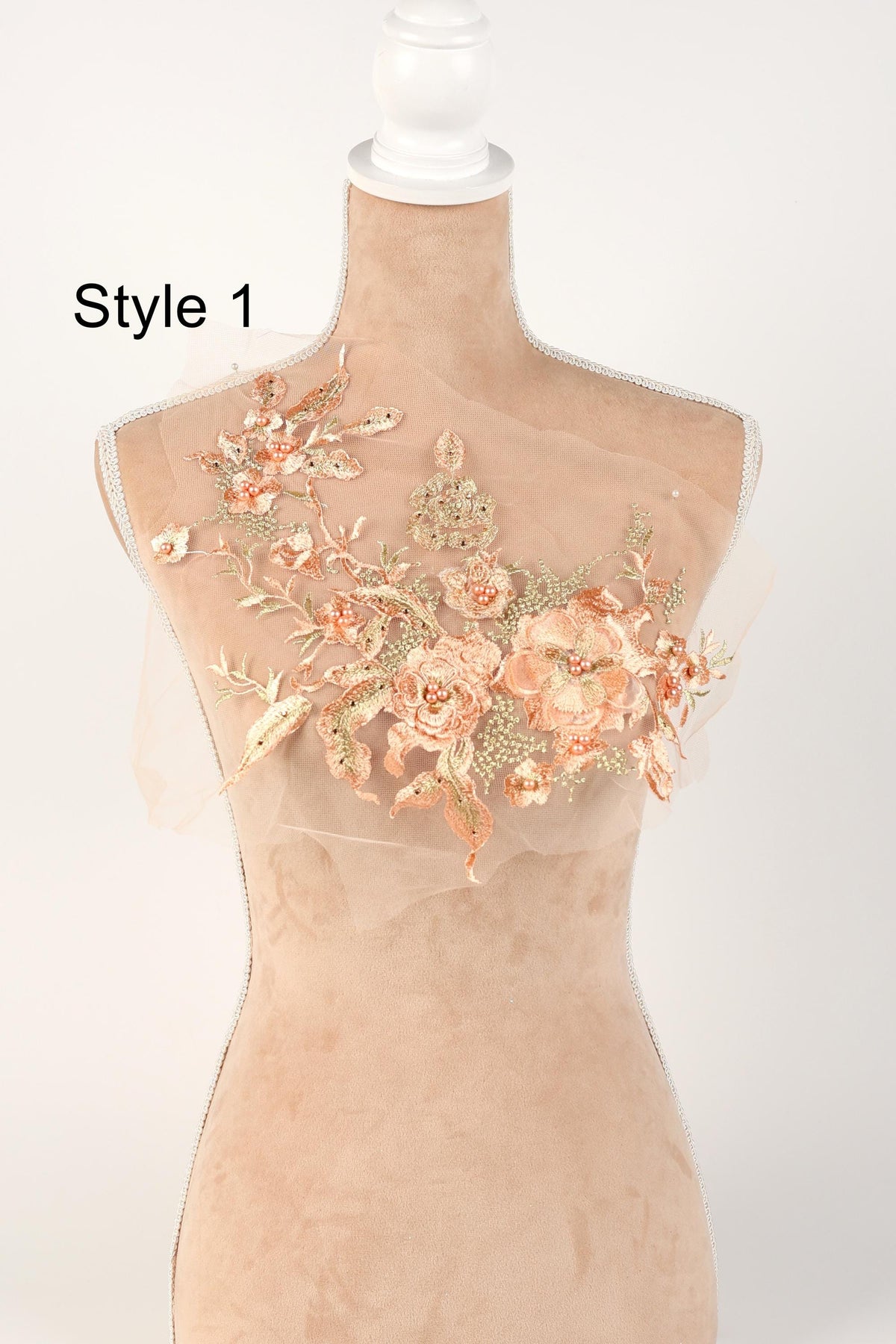 A mannequin with a floral design on its bust, featuring a combination of pink and peach flowers.