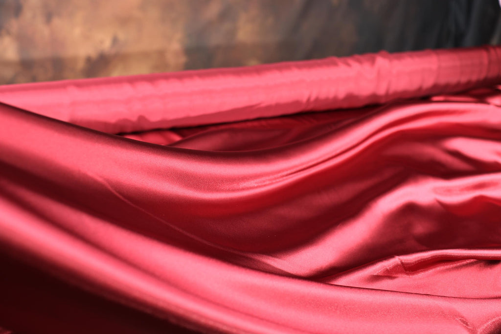 a close up of a red cloth on a bed