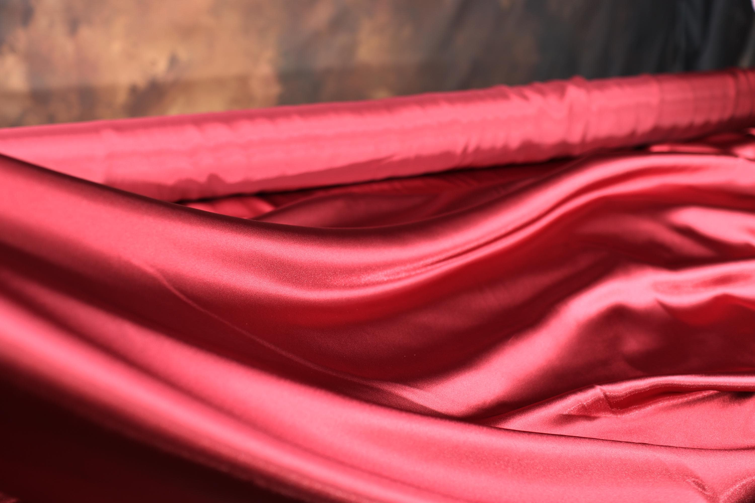 a close up of a red cloth on a bed