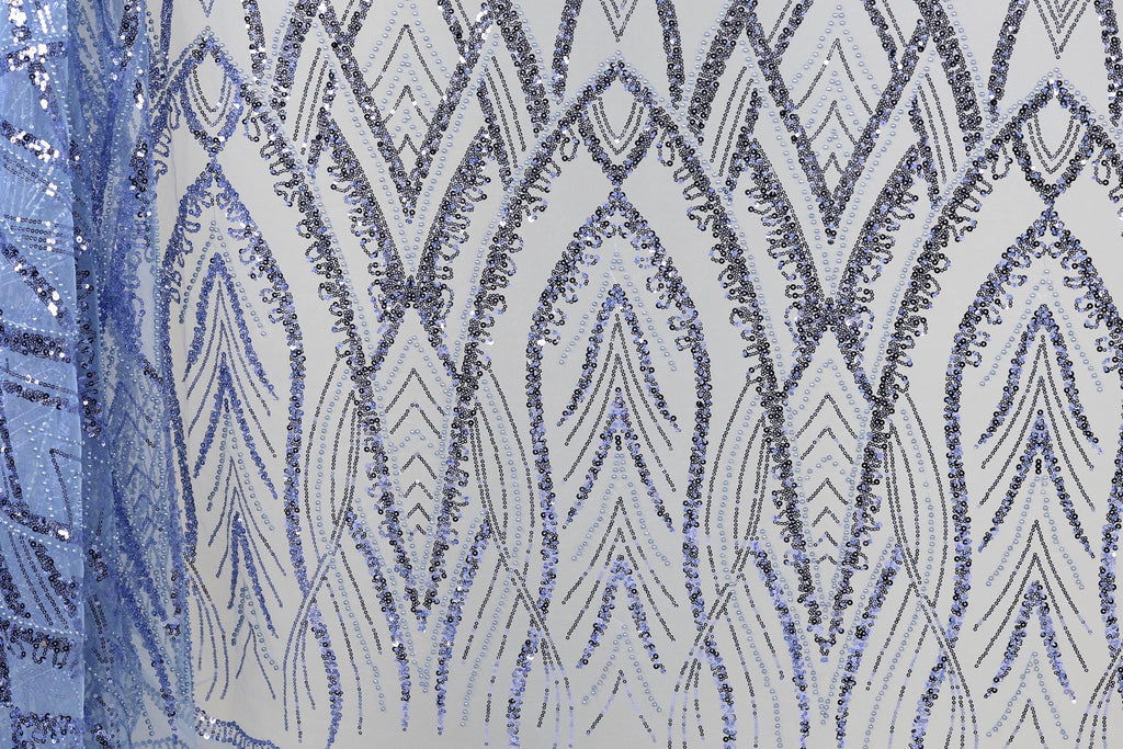 a close-up view of a fabric with a repeating pattern of blue and silver sequins. The pattern consists of a series of arched shapes and lines, creating a visually striking and intricate design. The fabric appears to be a piece of clothing or textile, with the sequins adding a touch of sparkle and elegance to the overall appearance.