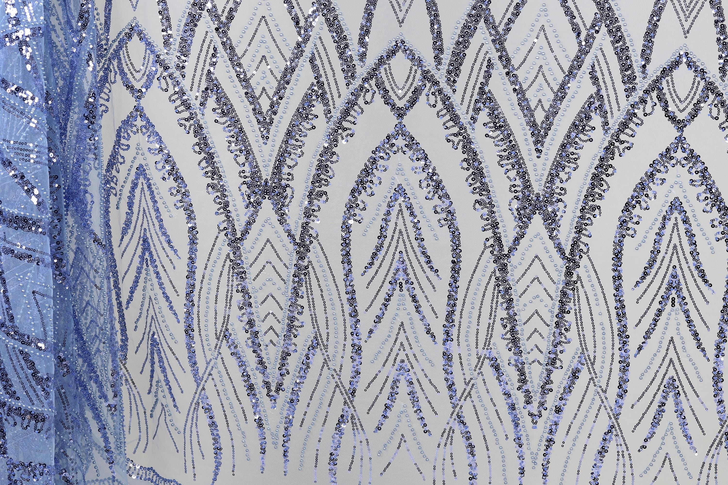 a close-up view of a fabric with a repeating pattern of blue and silver sequins. The pattern consists of a series of arched shapes and lines, creating a visually striking and intricate design. The fabric appears to be a piece of clothing or textile, with the sequins adding a touch of sparkle and elegance to the overall appearance.