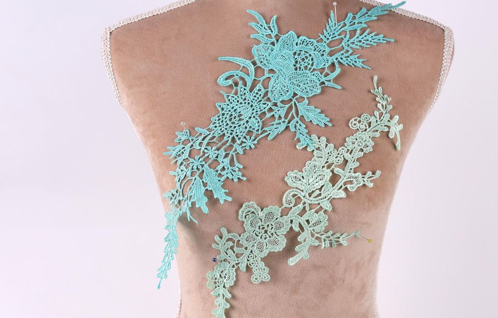 a mannequin torso with a decorative floral lace piece attached to it.