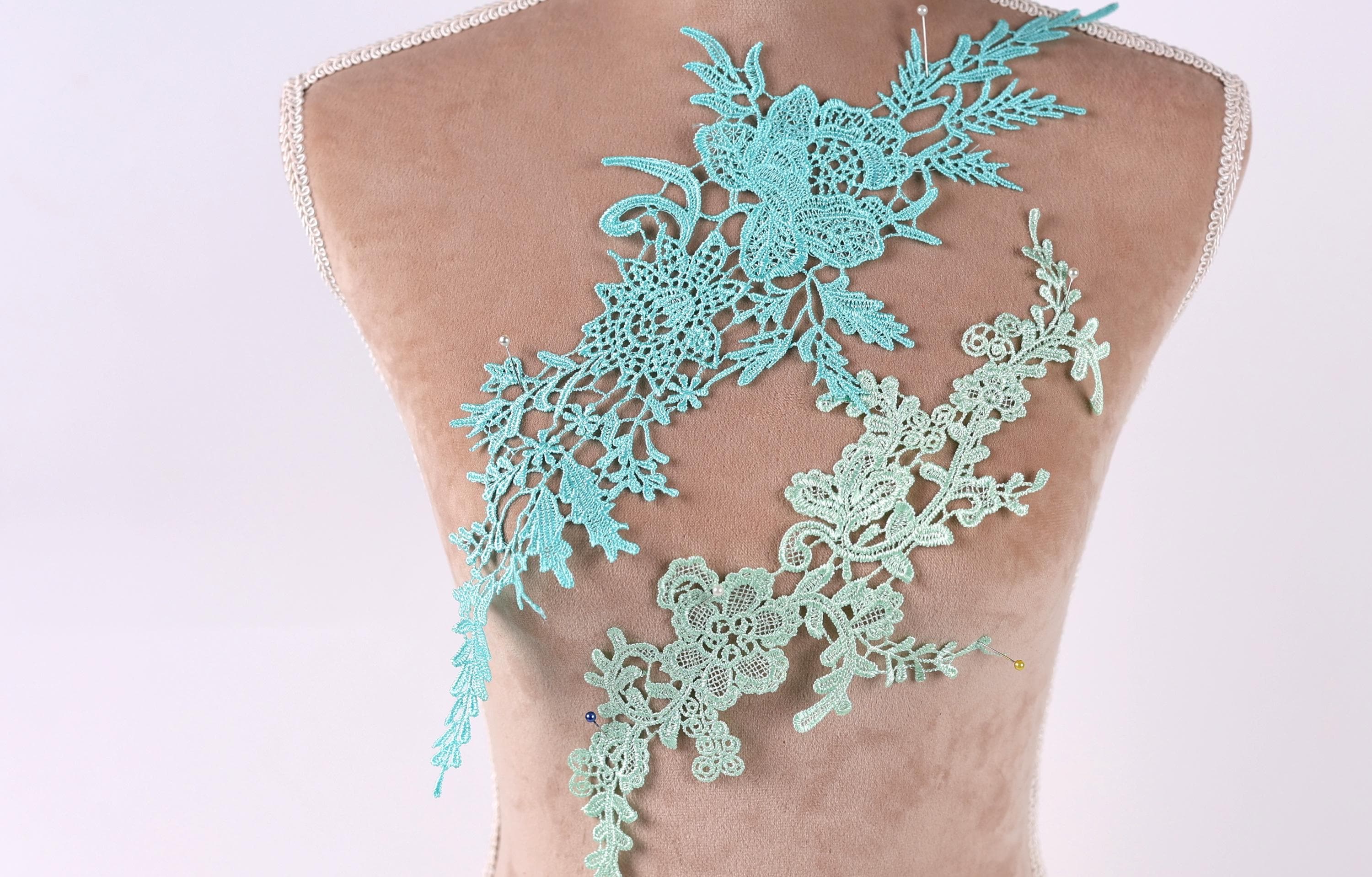 a mannequin torso with a decorative floral lace piece attached to it.