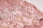 a close-up view of a pink and gold sequined fabric, with intricate patterns and designs.