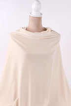 A mannequin wearing a cream-colored fabric draped over its body.