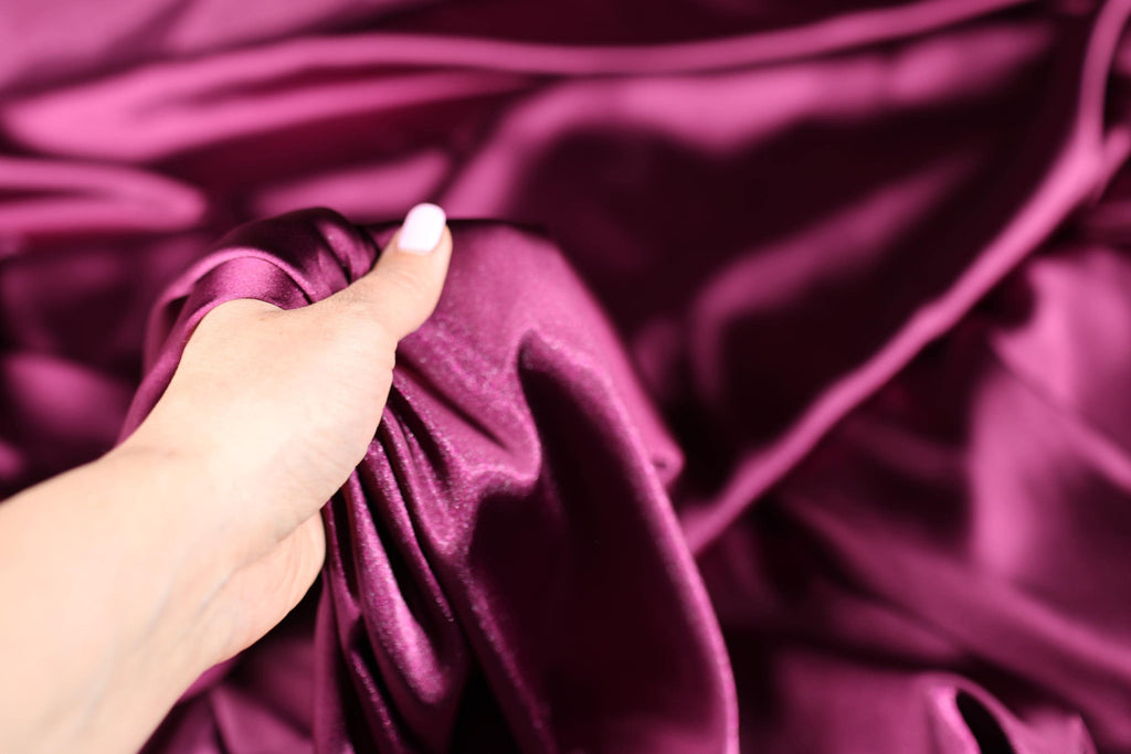 a person&#39;s hand holding a purple cloth
