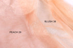 a close-up of a light peach-colored fabric with a glittery texture, with two labels indicating the fabric type and color.